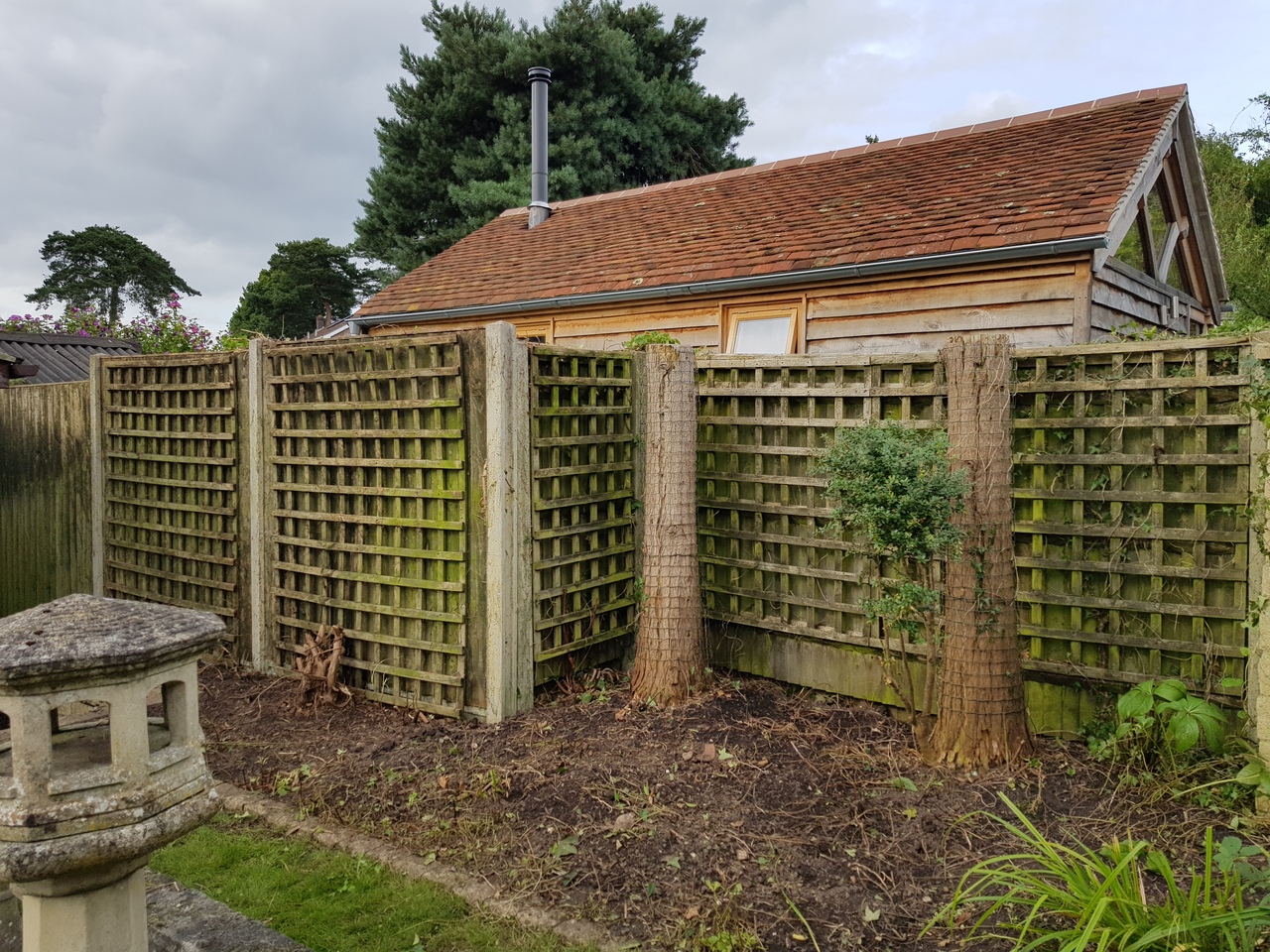 picture of a recently cleared garden trellis fence and flowerbeds